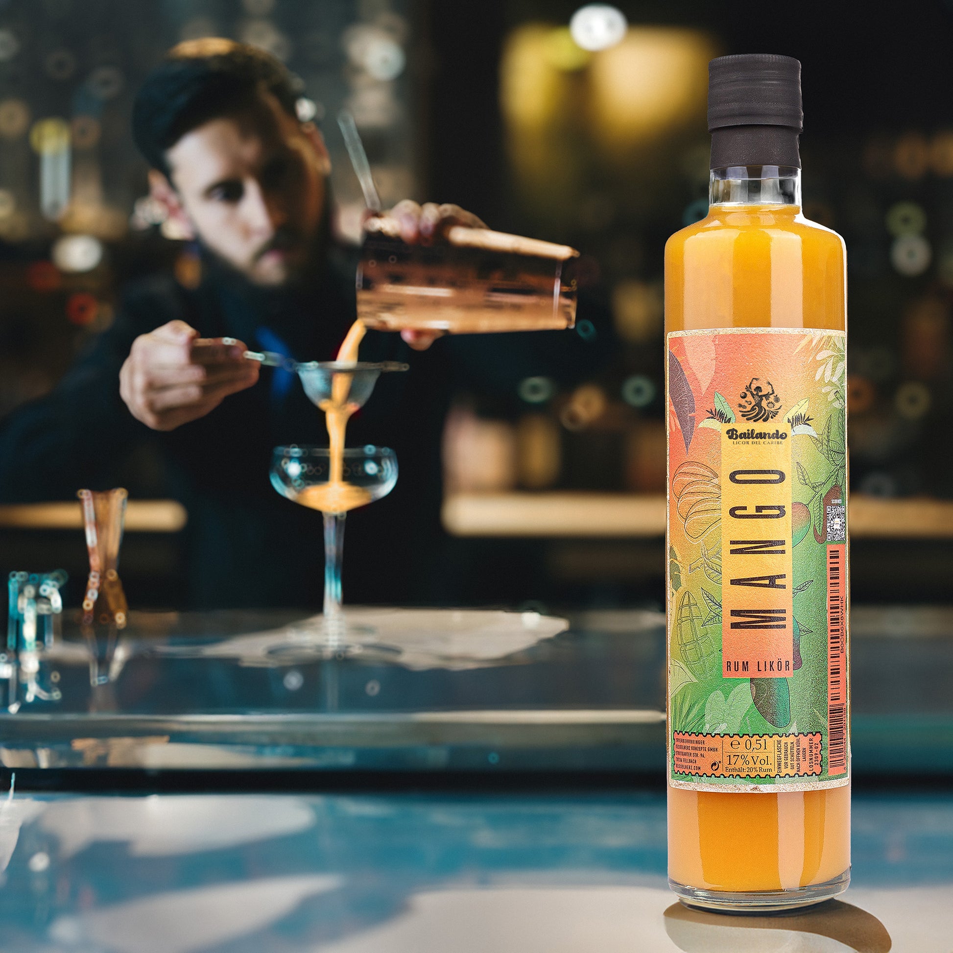 Bailando Frucht Rum Likoer, Geschmacksrichtung Mango, im Hintergrund ein Bartender, der einen exquisiten drink mixt.