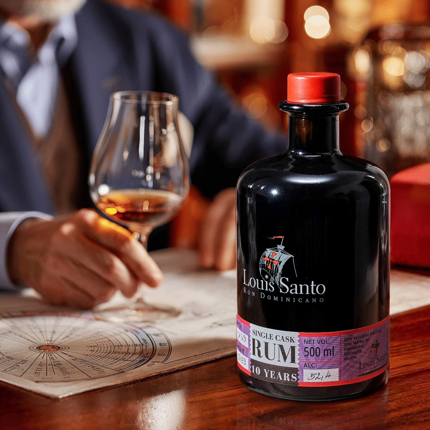 Flasche Louis Santo Rum 10 Jahre mit Glas auf Tisch, Person im Hintergrund